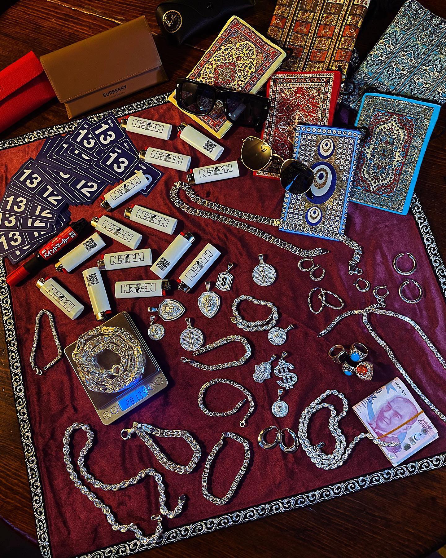 Wooden shelf with gray and olive drab green baseball caps, next to wooden clothes hanger with sweaters.